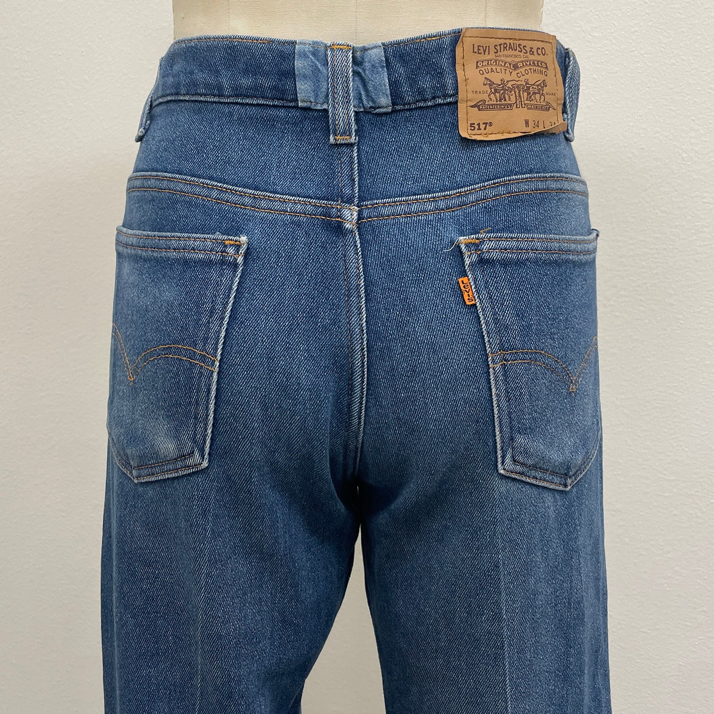 Blue jeans with Levi's 517 branding on a plain background