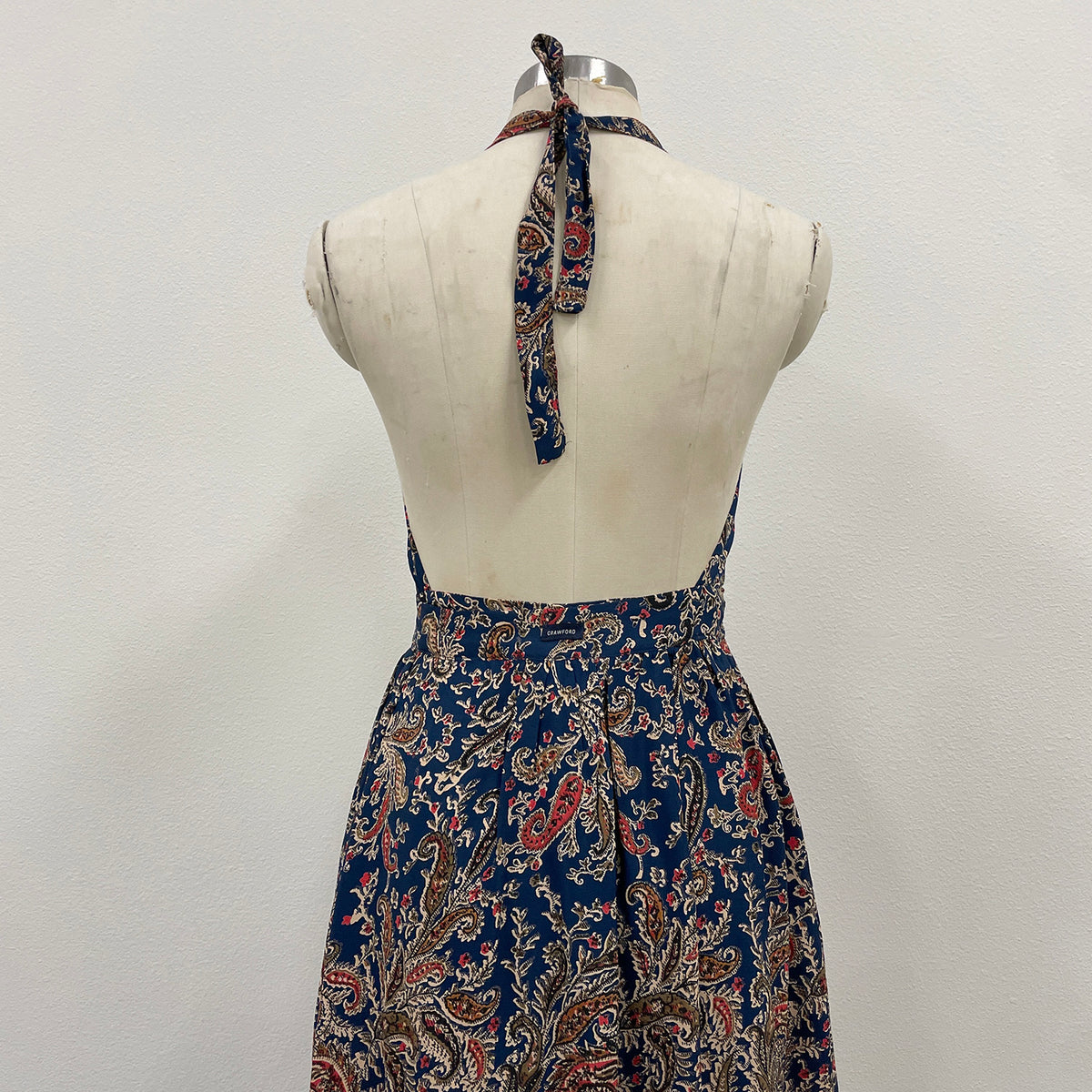 Blue patterned dress on a mannequin against a white background