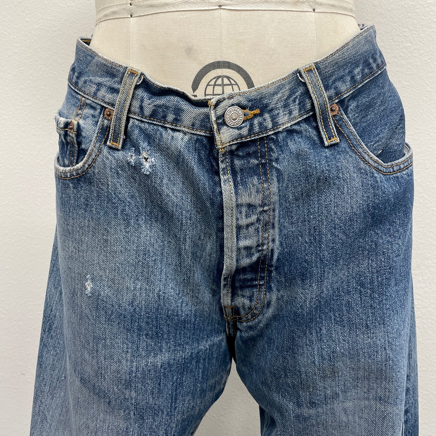 Blue jeans with slight distressing on a plain background