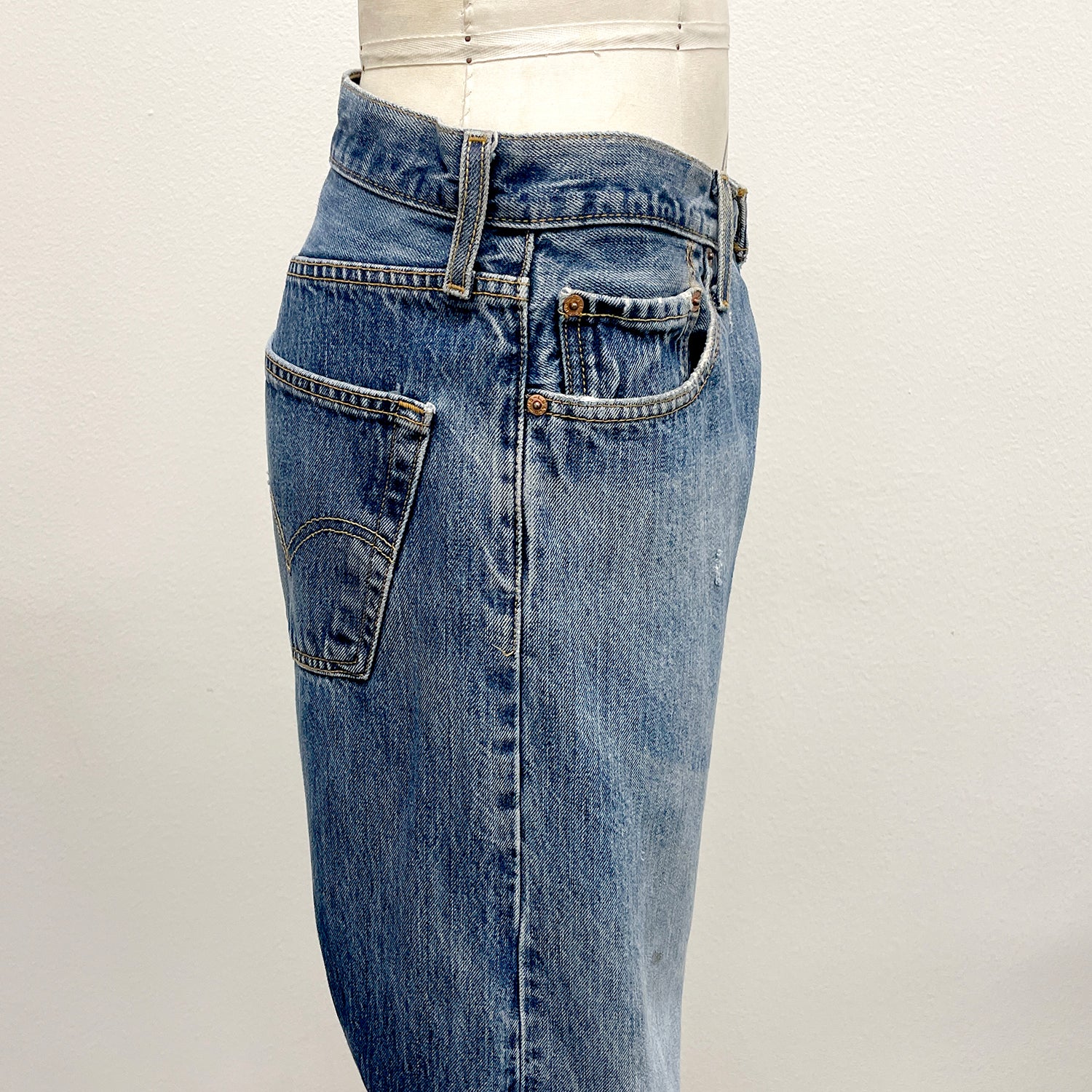 Blue jeans on a mannequin against a white background