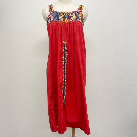 Red dress with colorful embroidery on a mannequin against a white background
