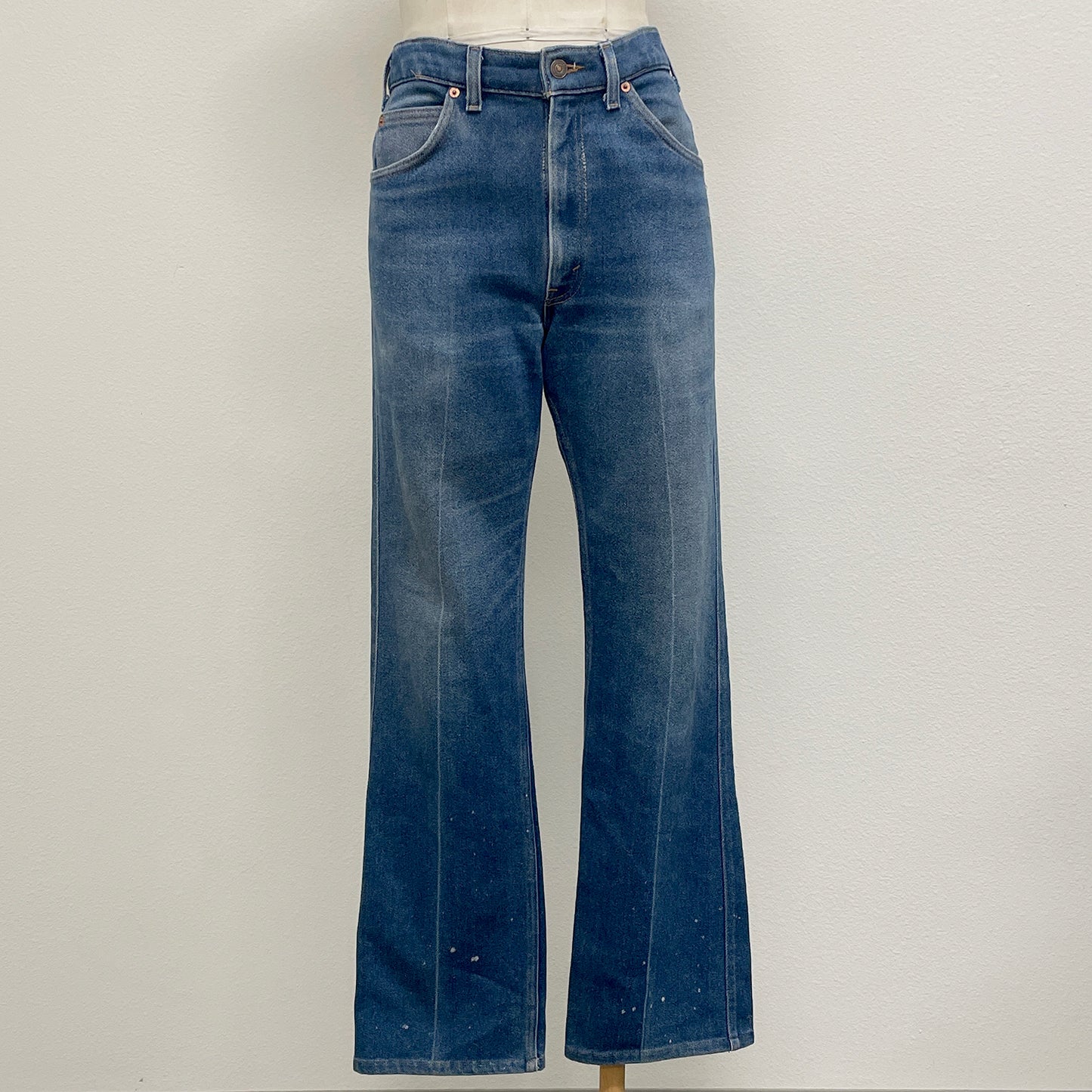 Blue jeans on a mannequin against a plain background