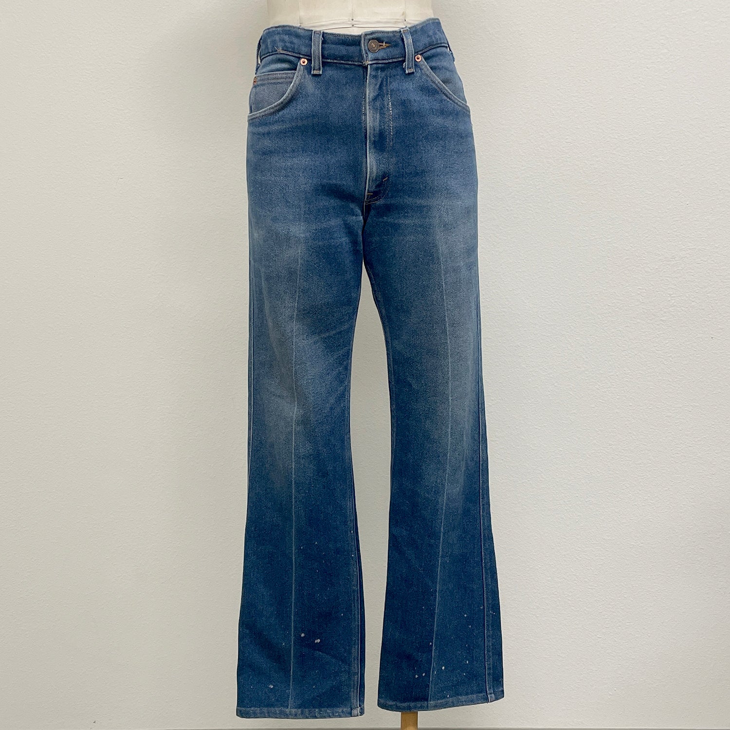 Blue jeans on a mannequin against a plain background