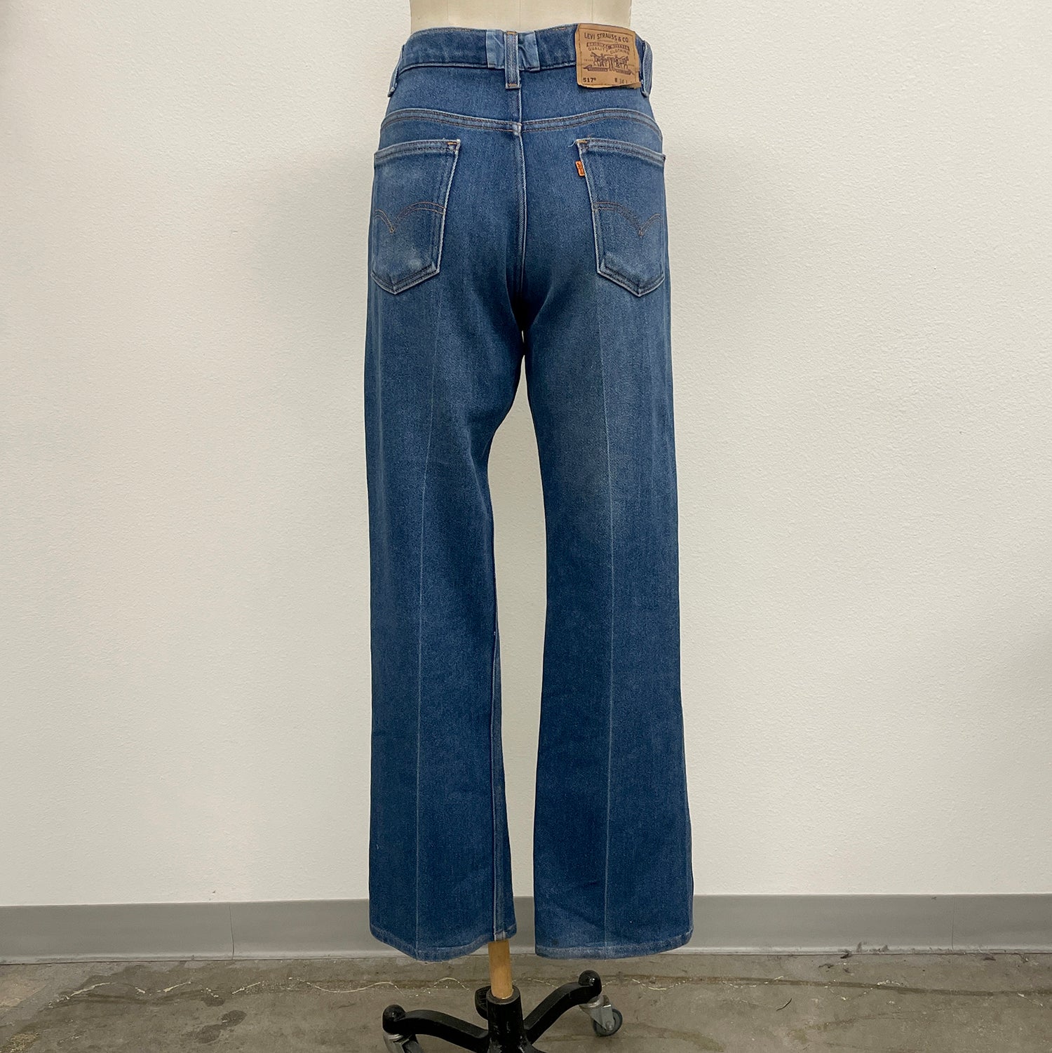 Blue jeans on a mannequin against a plain background