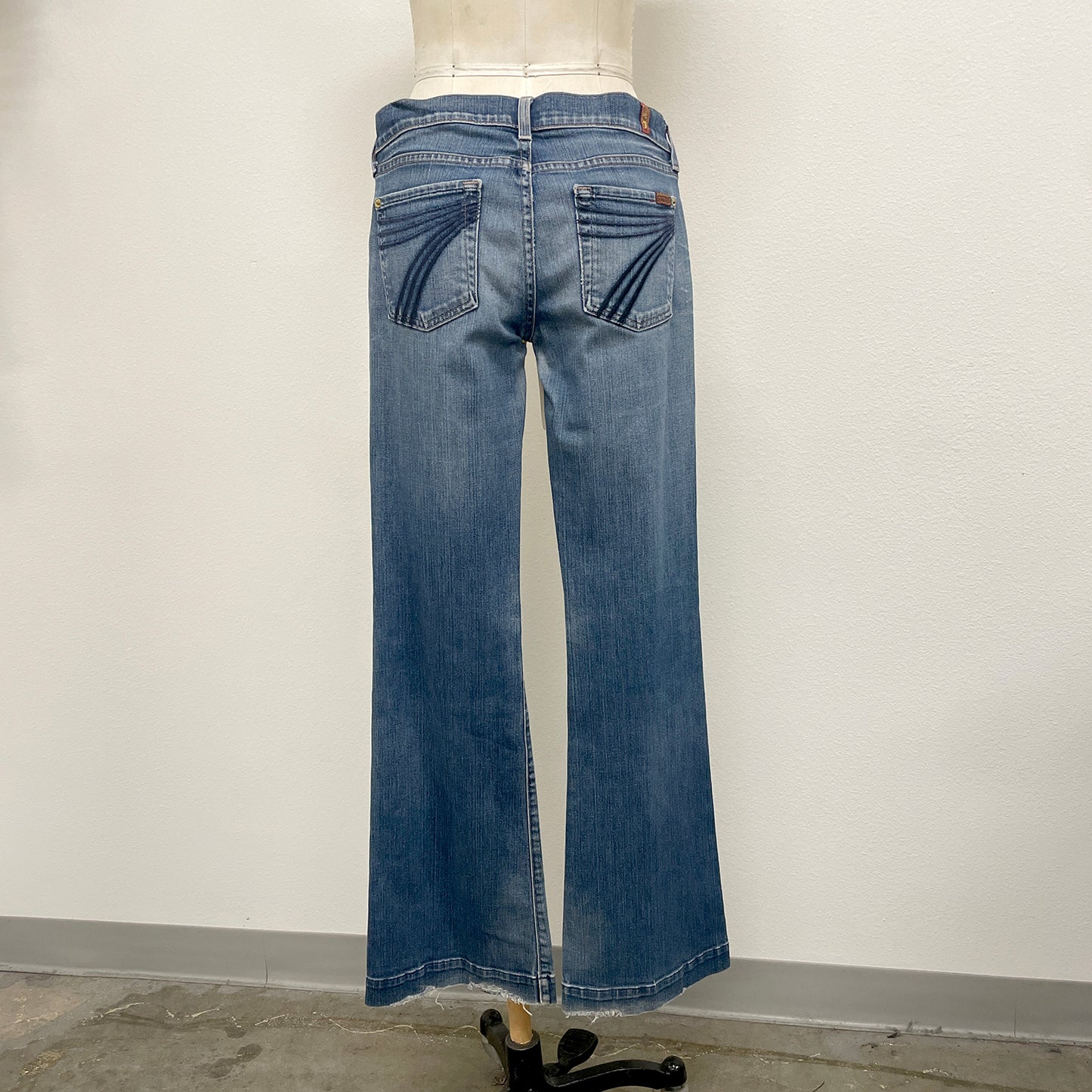 Blue jeans on a mannequin against a plain background