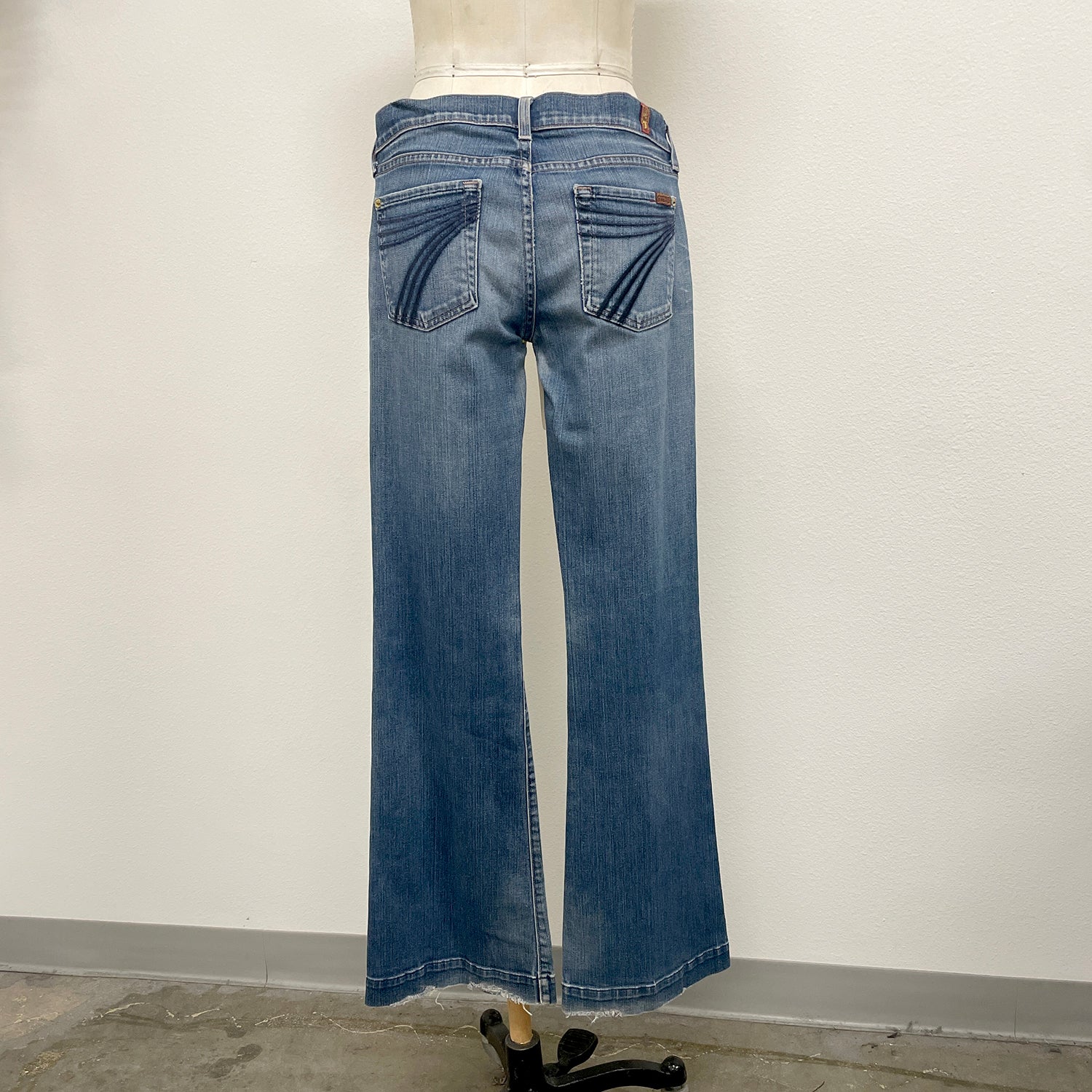 Blue jeans on a mannequin against a plain background