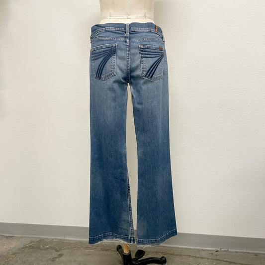 Blue jeans on a mannequin against a plain background