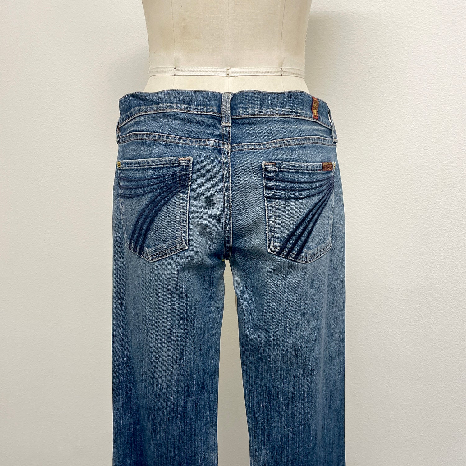 Blue jeans on a mannequin against a white background