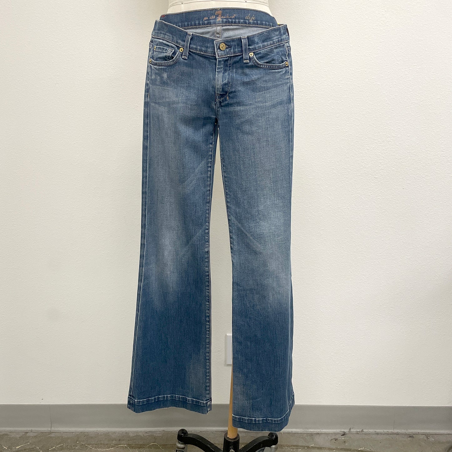 Blue jeans on a mannequin against a plain background