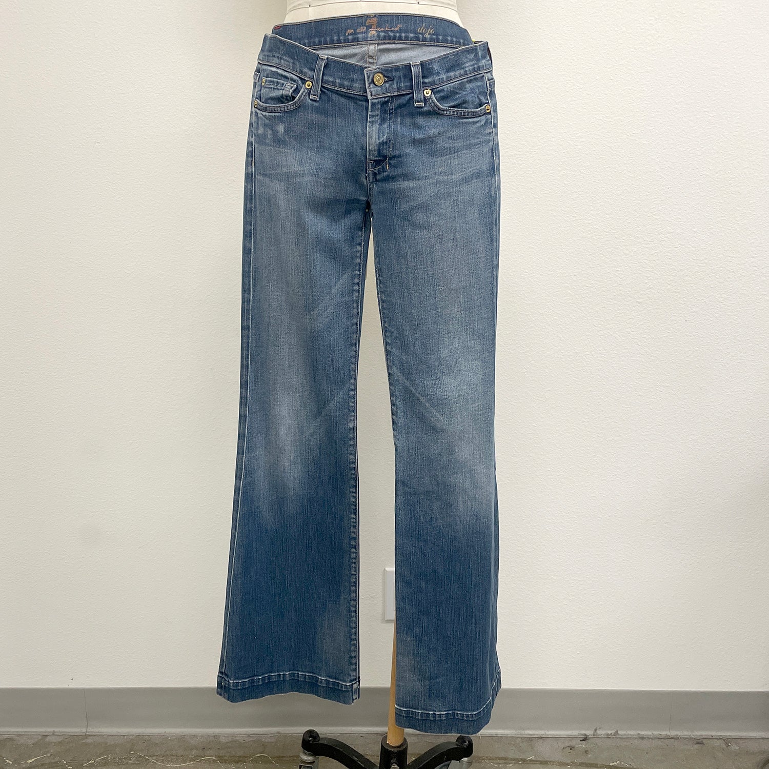 Blue jeans on a mannequin against a plain background