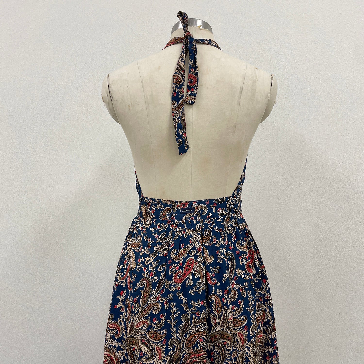 Blue patterned dress on a mannequin against a white background