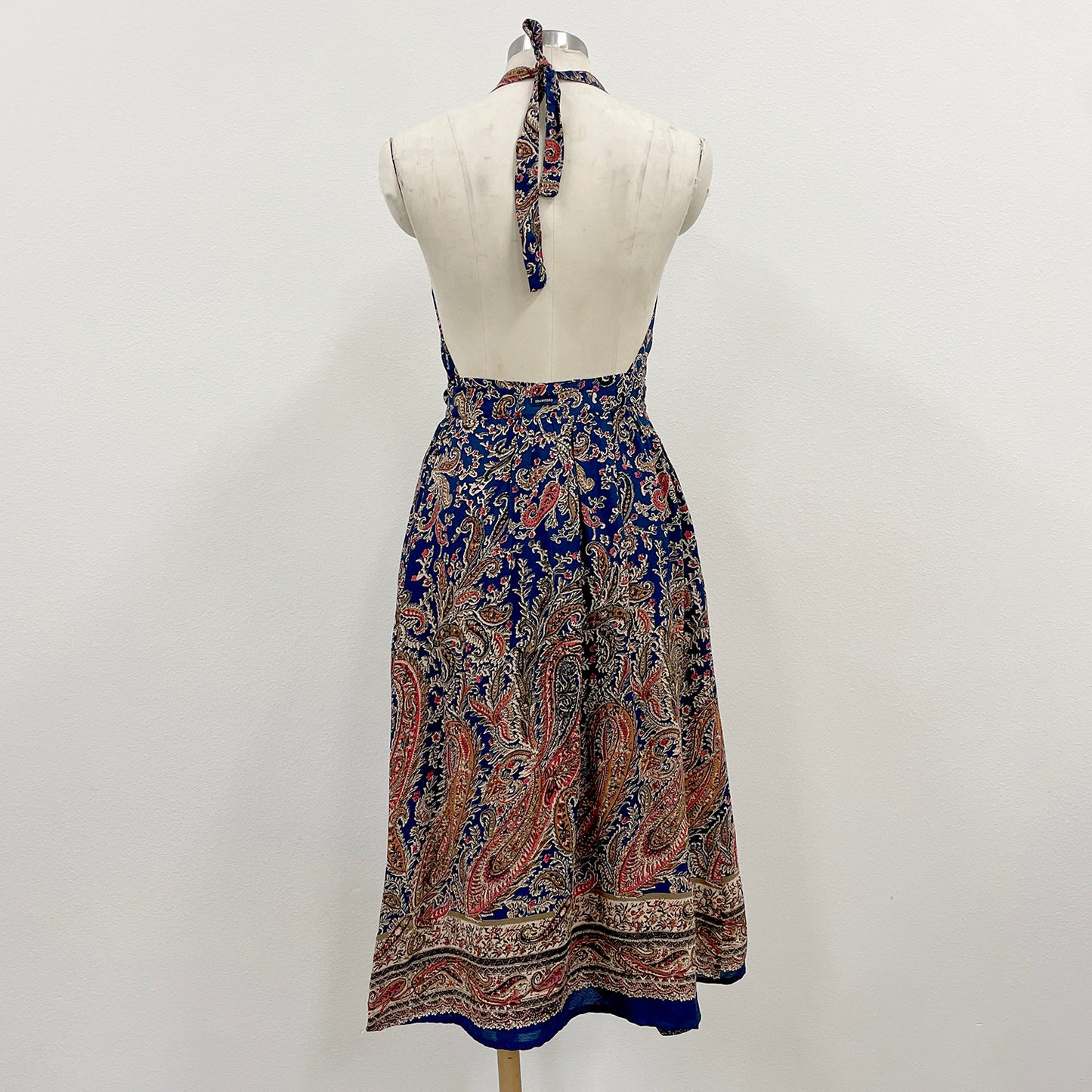 Patterned dress on a mannequin against a plain background