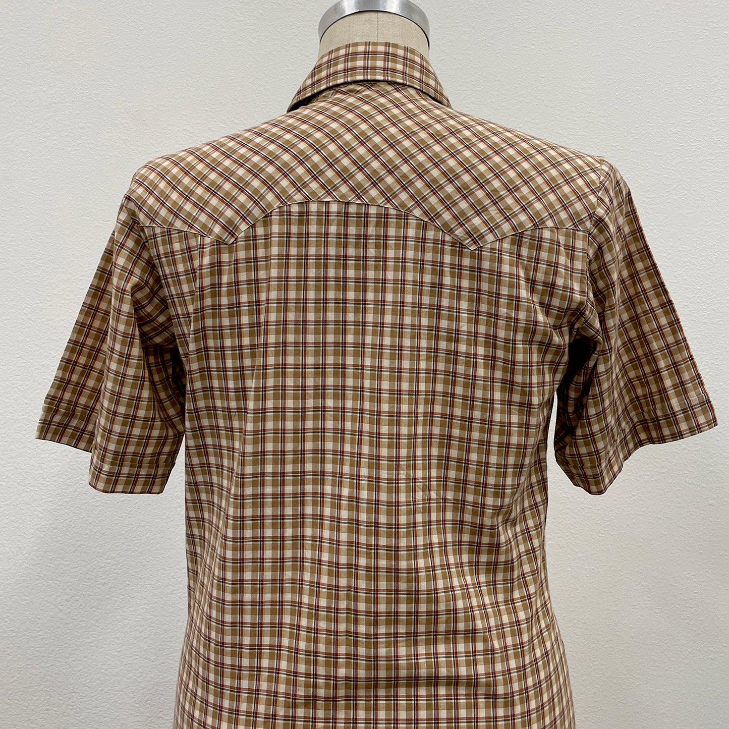 Plaid shirt on a mannequin against a plain background