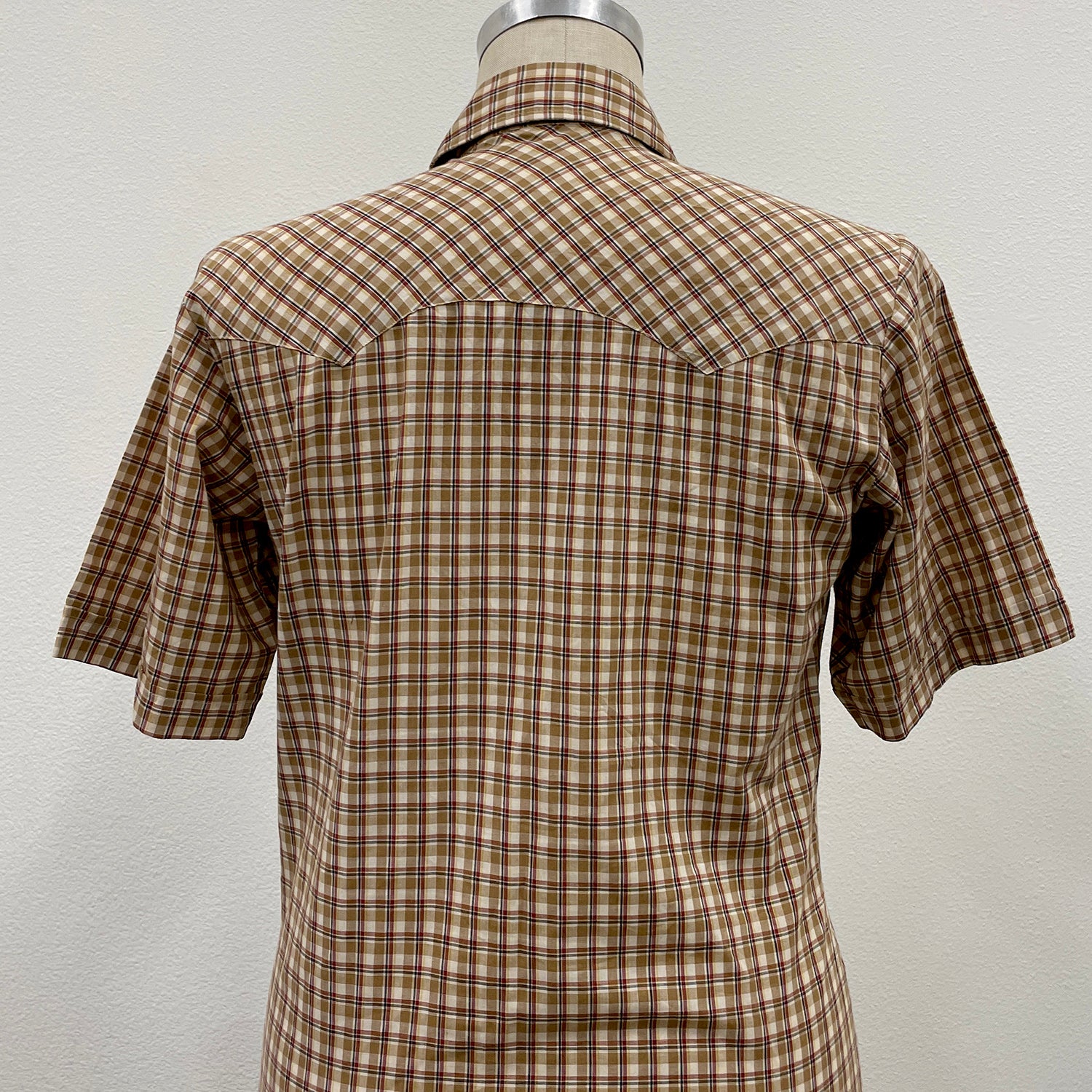 Plaid shirt on a mannequin against a plain background
