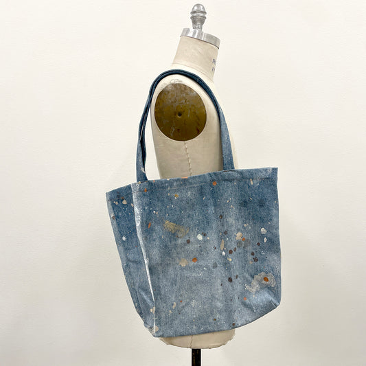 Blue denim tote bag on a mannequin against a white background