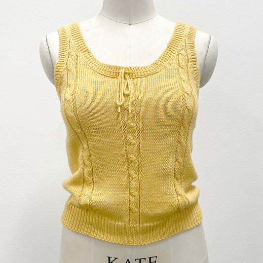 Yellow knitted sleeveless sweater tank on a mannequin against a white background