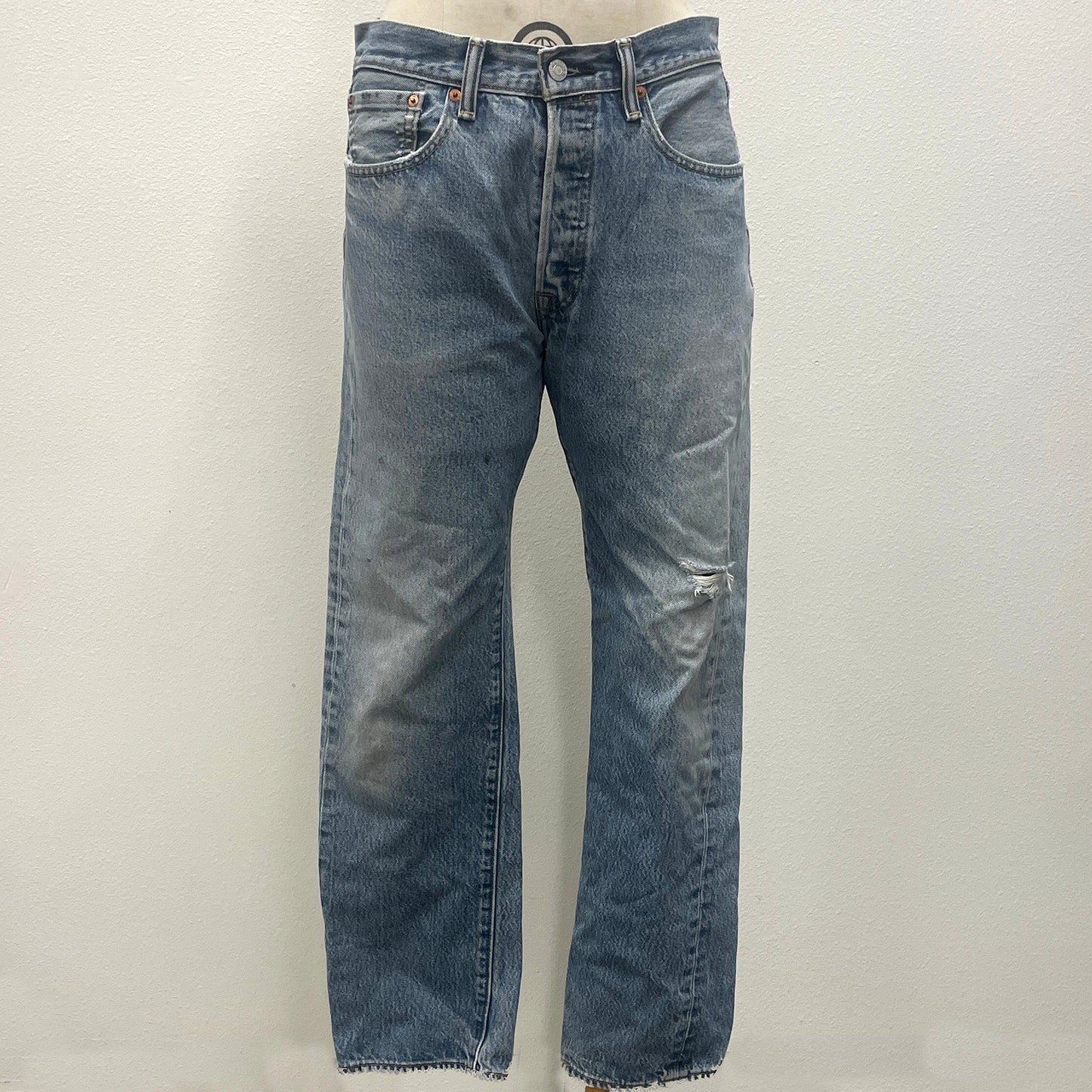 Pair of faded blue jeans on a light gray background