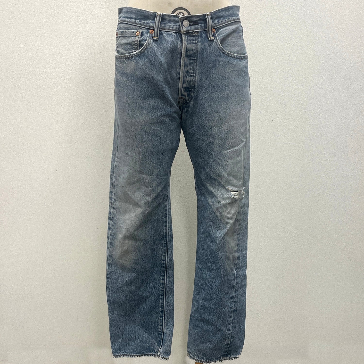 Pair of faded blue jeans on a light gray background