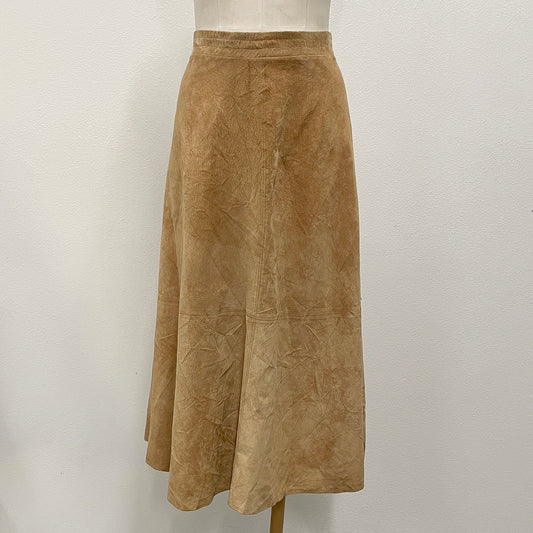 A tan suede A-line midi skirt displayed on a mannequin torso against a white wall.
